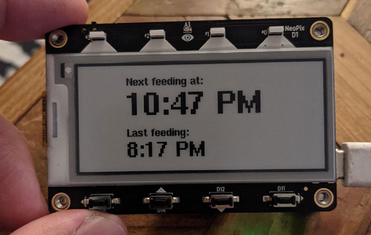 A photograph of an eInk display showing the next feeding should be 10:47 PM and the last feeding at 8:17PM.