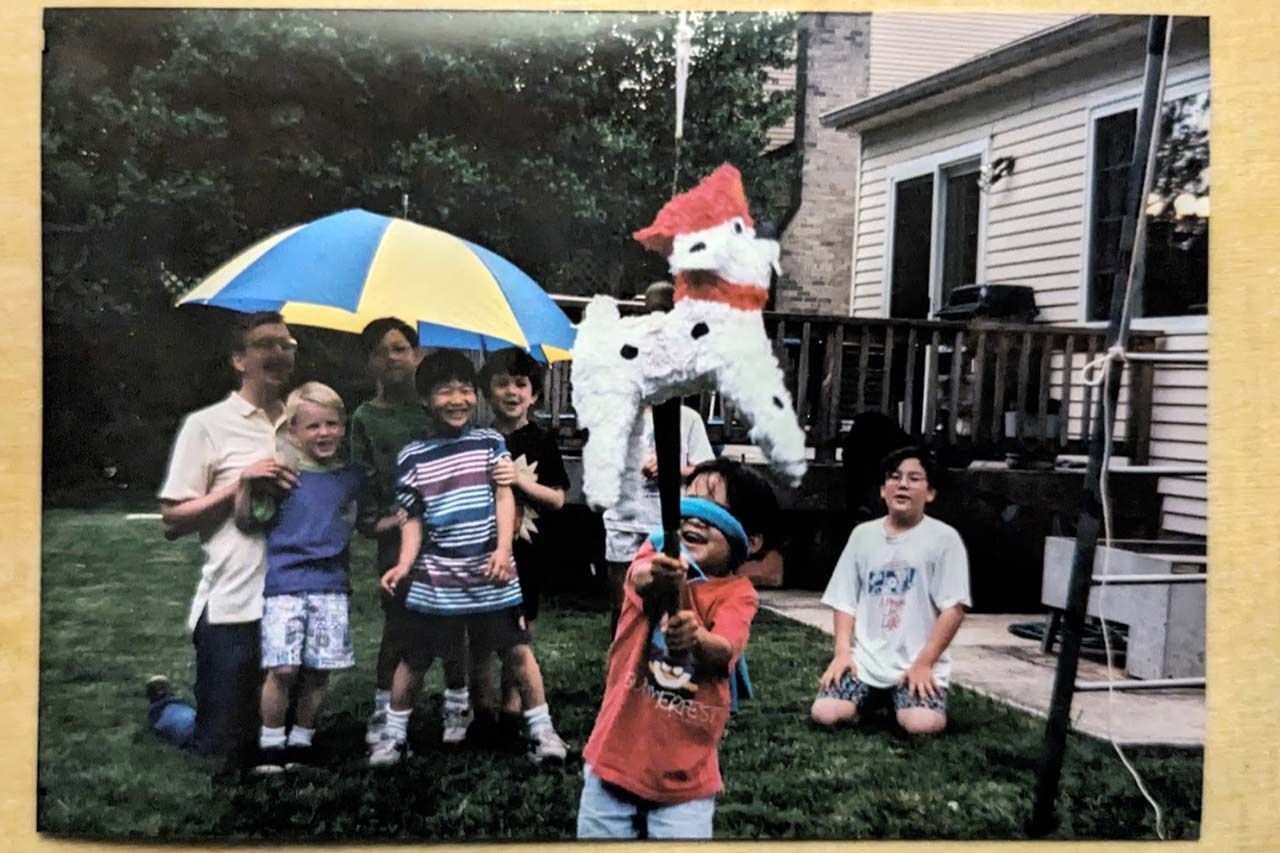 A film photograph of the author as a kid striking a pinata dalmatian with a baseball bat