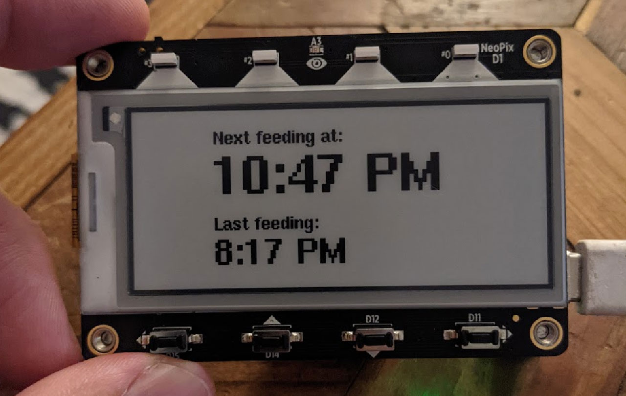 A photograph of an eInk display showing the next feeding should be 10:47 PM and the last feeding at 8:17PM.